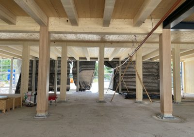 Blick auf den künftigen Haupteingang (von der Schultheißallee aus). Gut zu erkennen ist ein provisorisches Entwässerungsrohr, über das auf dem Boden des 1. OG stehendes Regenwasser abgeleitet werden kann.